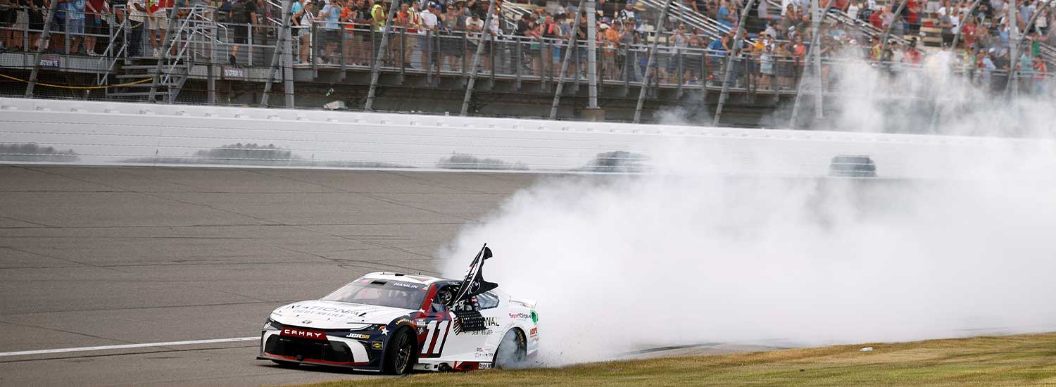 Denny Hamlin, driver of the #11 National Debt Relief Toyota, celebrates with a burnout after winning the NASCAR Cup Series FireKeepers Casino 400 at Michigan International Speedway on June 07, 2026 in Brooklyn, Michigan. (Photo by Sean Gardner/Getty Images)